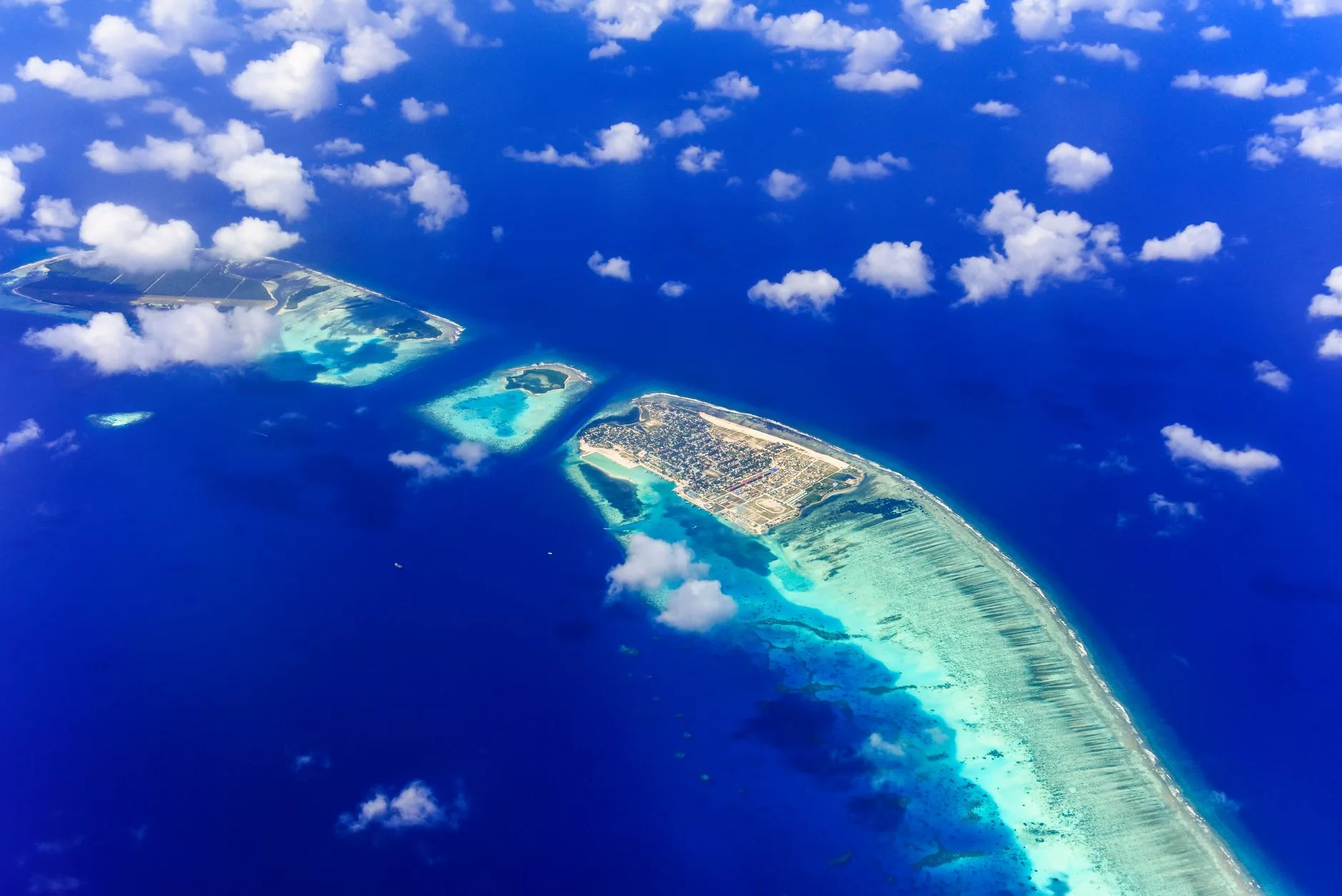 Vue aérienne de l'atoll d'Addu aux Maldives, avec ses lagons turquoise et ses îles reliées par la route de liaison