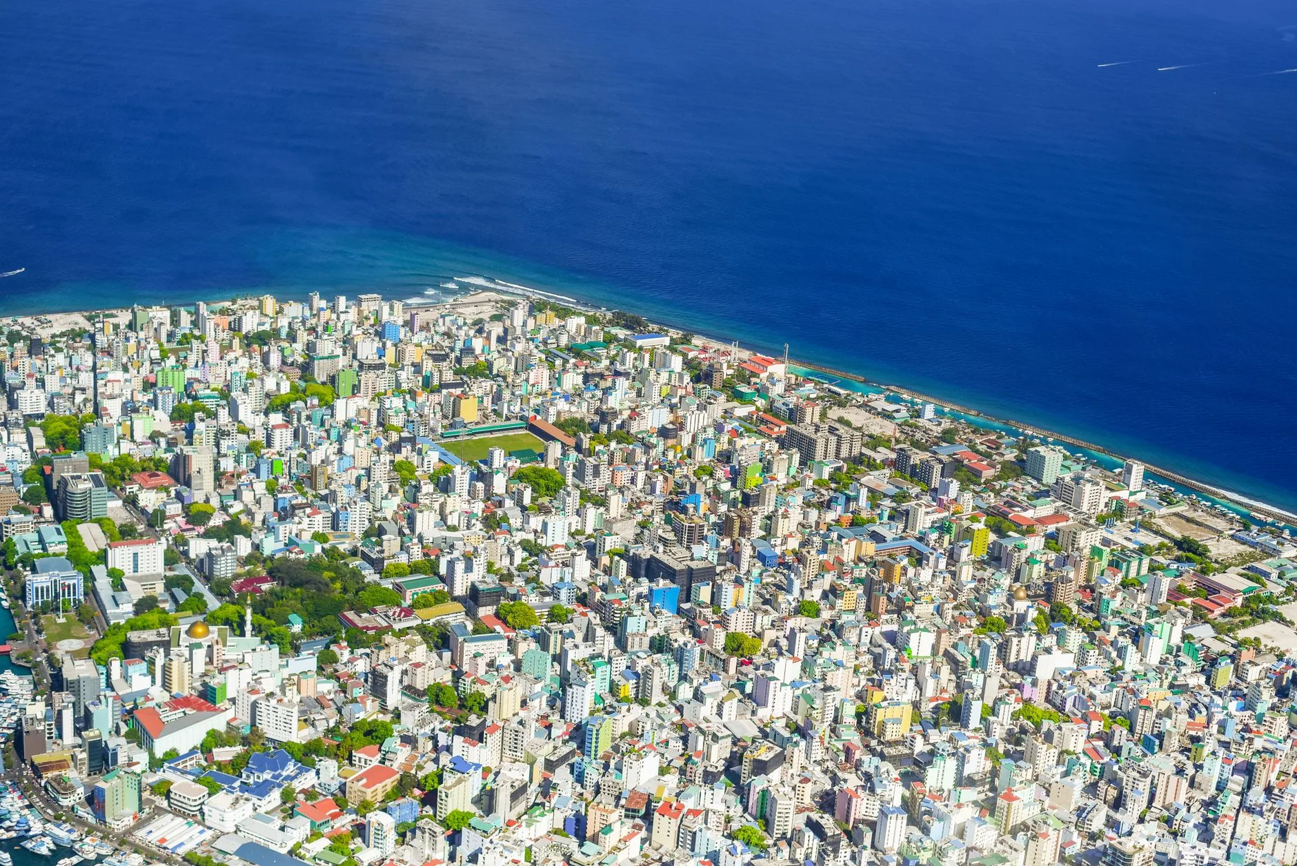 Vue aérienne de Malé, capitale des Maldives, avec la grande mosquée dorée et le bord de mer animé